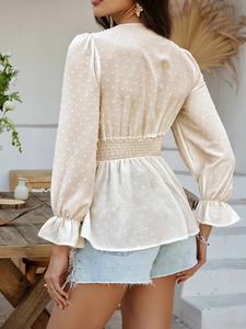 Vue arrière du haut beige à col en V avec tissu jacquard à pois et taille élastiquée