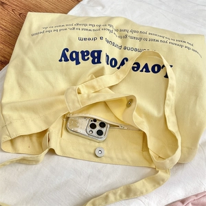 Detail of the large canvas tote bag interior showing the magnetic buckle and zip pocket