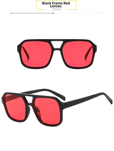 Detail view of square black frames with vibrant red lenses and double bridge design