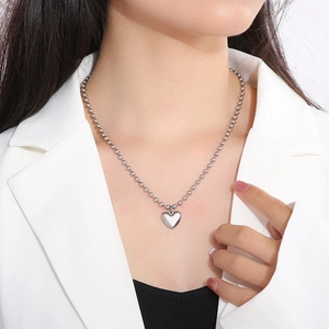 Gros plan d'un pendentif cœur argenté et d'une chaîne à billes sur un mannequin pro