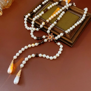 Detailed view of multilayer pearl necklace with amber crystals on a vintage frame