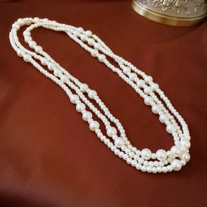 Three-layer multilayer pearl necklace for women featuring elegant cream pearls on red fabric