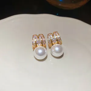 Elegant gold letter M earrings with zircon pavé and large round hanging pearls