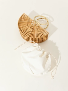 Detail of hollow bamboo handbag with natural joint handles and white canvas pouch insert