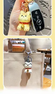 Detail of resin wood-carved style cat and dog keychains with Ping An charms on bag