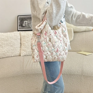 Détail latéral du sac cabas matelassé avec motifs lapin et bandoulière rose