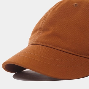 Dettaglio del berretto da baseball in twill di cotone arancione con cuciture di precisione