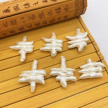 Macro detail of six white baroque pearls with irregular shape on classical bamboo mat