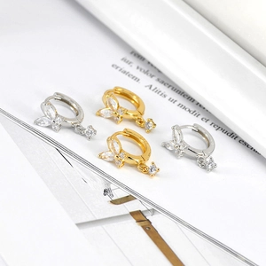 Macro shot of butterfly hoop earrings with marquise zircon stones in gold and silver finish