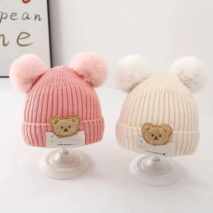 Children's knitted winter hats with cute pom-poms and cartoon bear patch in pink and beige