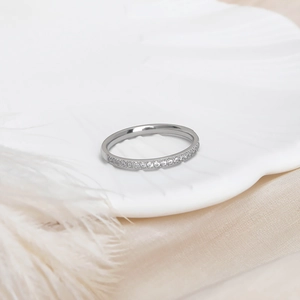 Macro shot of silver micro-pave cubic zirconia band on a white shell and silk backdrop