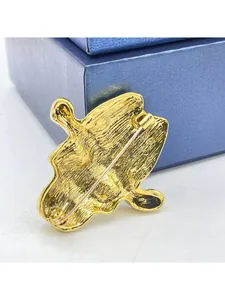 Close-up of the vintage golden metal skeleton brooch showing the pin fastening mechanism