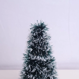 Close-up of mini artificial Christmas tree with flocked snow effect and green needles