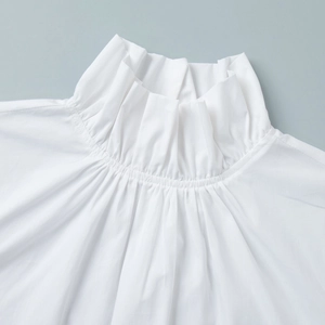Detail of elegant white pie collar blouse with intricate pleated ruffled neckline