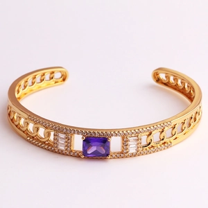 Close-up of gold chain-style open bangle featuring a large purple square zircon stone