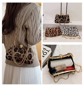 Macro shot of a leopard print box clutch bag featuring a large pearl clasp and gold chain