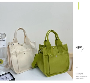 Detail of green and white canvas tote bags with adjustable straps and metal snaps