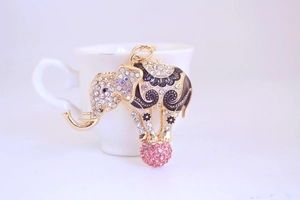 Close-up of gold flying elephant keychain with rhinestones and pink crystal ball