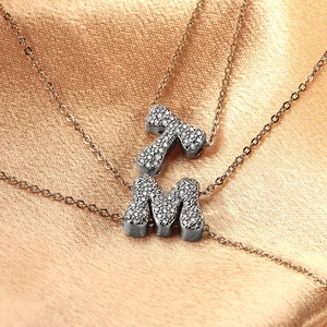 Elegant copper alphabet necklace with T and M pendants inlaid with cubic zirconia
