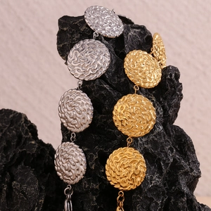 Dettaglio macro di bracciali a catena con dischi martellati in oro e argento