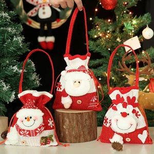 Three Christmas knitted gift bags with Santa, Snowman and Reindeer on festive background