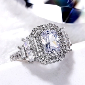 Dettaglio macro dell'anello halo di lusso con taglio smeraldo e pietre laterali