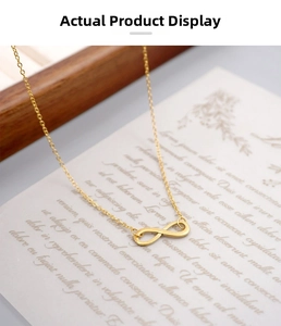 Macro shot of gold infinity pendant necklace with fine chain on elegant stationery