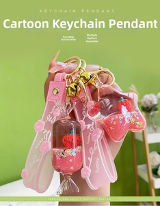 Detail of strawberry liquid quicksand keychain with pink lucky strap and golden hardware