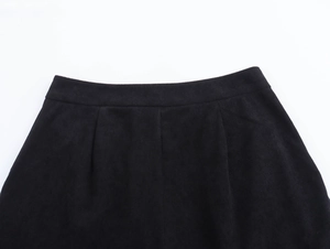 Dettaglio dei pantaloncini di velluto nero con vita elastica e dettagli delle pieghe