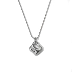 Detailed close-up of irregular silver wave pendant on a sleek snake chain necklace