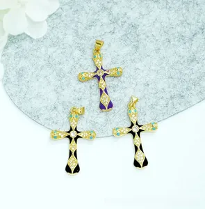 Macro detail of 18K gold plated cross pendants with enamel inlay and zircon accents