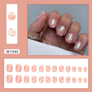 Faux ongles rose pâle avec motifs floraux blancs et finition aurore scintillante