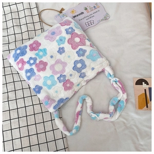 Close-up of fluffy white plush shoulder bag with colorful floral prints and soft texture