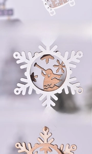 Detail of laser-cut wooden Christmas snowflake ornament with white painted finish and angel