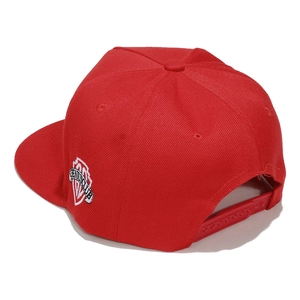 Detail of red flat brim snapback hat showing adjustable plastic strap and side embroidery