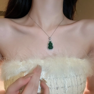 Detail of green resin gourd pendant with shimmering zircon accents on silver chain