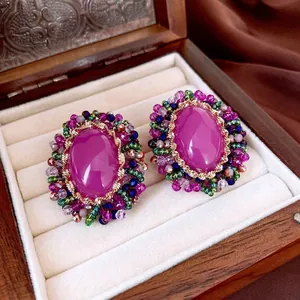 Vintage oval crystal flower earrings with purple gemstones and colorful beads on velvet