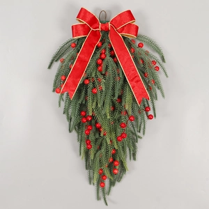 Detailed view of teardrop Christmas swag with red bow, pine needles and berries