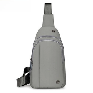 Detail view of grey nylon chest bag featuring dual zipper compartments and top handle