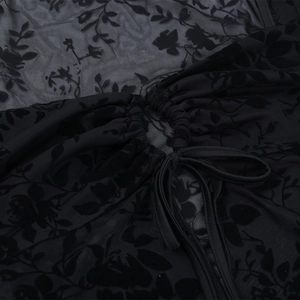 Détail du haut en tulle noir avec motifs de roses en velours et cordon de serrage froncé