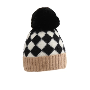 Winter knit baby hat with black and white argyle pattern and fluffy pompom detail