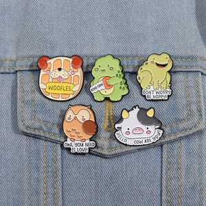 Close-up of five cute animal enamel pins displayed on a blue denim jacket pocket