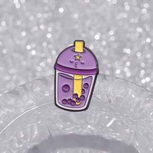 Cute purple bubble tea enamel pin featuring a cartoon face and glittery background