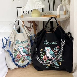 Close-up of embroidered parrot on nylon tote bag with drawstring braided rope handles