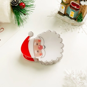 Close-up of Santa Claus hair claw clip made of acrylic with festive holiday decorations