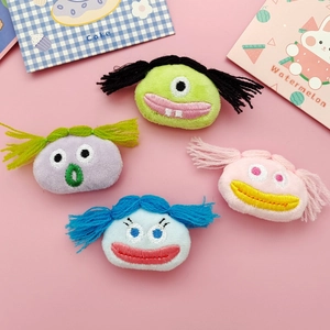 Macro shot of colorful plush cartoon doll heads for DIY hair accessories and brooch pins
