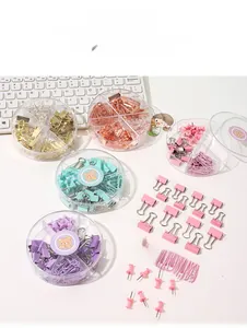 Detail of macaron color binder clips and paperclips in a divided round organizer box