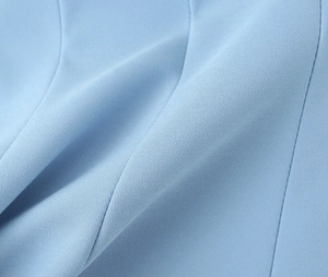 Macro detail of the light blue woven fabric texture with soft folds and elegant drape