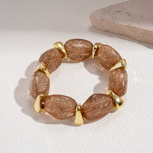 Close-up of amber acrylic oval beads with gold glitter and metallic spacers on the bracelet