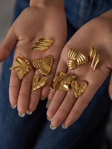 Close-up of several 18K gold plated titanium steel earrings in unique geometric shapes